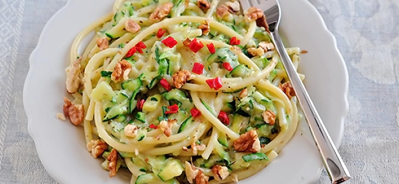 Pasta cremosa con verduras vegetales frutos secos y albahaca