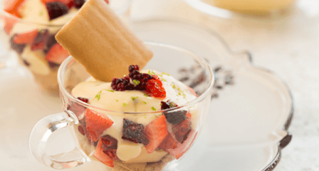 Postre de crema y frutas rojas